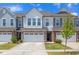 Charming townhome boasts a stone-accented facade, a one-car garage, and well-maintained landscaping at 242 Luftee Ln, Holly Springs, NC 27540