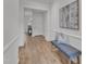Bright hallway with hardwood floors, bench seating, artwork, and an open doorway at the end at 242 Luftee Ln, Holly Springs, NC 27540