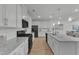 Modern kitchen with white cabinetry, granite countertops, and stainless steel appliances and hardwood floors at 242 Luftee Ln, Holly Springs, NC 27540