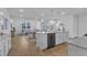 Open-concept kitchen with stainless steel appliances, a center island and access to the living and dining areas at 242 Luftee Ln, Holly Springs, NC 27540