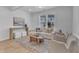 Cozy living room featuring modern furniture, a patterned rug, and natural light from a large window at 242 Luftee Ln, Holly Springs, NC 27540