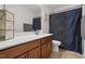 Bright bathroom features a single vanity with wooden cabinets and a shower with a patterned curtain at 250 Hawksbill Dr, Franklinton, NC 27525
