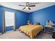 A bedroom showcases a vibrant blue wall, neutral carpet, a bed, a window with blinds, and two side tables at 250 Hawksbill Dr, Franklinton, NC 27525