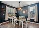 The dining room features a dark accent wall, modern light fixture, a table with seating for six, and two windows at 250 Hawksbill Dr, Franklinton, NC 27525