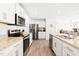 Modern kitchen with stainless steel appliances, granite countertops, and ample white cabinetry at 2512 Lily Dr, Haw River, NC 27258