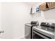 Functional laundry room with modern washer and dryer units, plus ample storage shelving at 2512 Lily Dr, Haw River, NC 27258