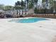 Community pool with clear blue water and ample concrete patio space and black fence at 2512 Lily Dr, Haw River, NC 27258