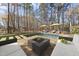 A stunning backyard with a pool, fire pit, lounge chairs, and mature trees, perfect for relaxation and entertainment at 2514 Mcgowan Ct, Wake Forest, NC 27587
