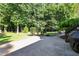 Backyard with a stone patio and winding path lined with mature trees, bushes, and a water feature at 2514 Mcgowan Ct, Wake Forest, NC 27587