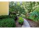 A lush backyard with a stone walkway lined with manicured bushes and trees. A natural setting at 2514 Mcgowan Ct, Wake Forest, NC 27587