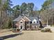 Charming two-story brick home featuring a landscaped lawn, dark roof, black shutters and mature trees at 2514 Mcgowan Ct, Wake Forest, NC 27587