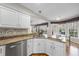 Kitchen island with granite counters, stainless dishwasher, and white cabinets overlooking breakfast nook and sunroom at 2514 Mcgowan Ct, Wake Forest, NC 27587