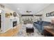 Spacious living room with hardwood flooring, a fireplace, comfortable sofas, and bright natural lighting at 2514 Mcgowan Ct, Wake Forest, NC 27587