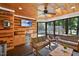 This bright sunroom features wood walls and ceiling, mini-fridge, ceiling fan, and serene views at 2514 Mcgowan Ct, Wake Forest, NC 27587