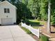 View of a home's side yard, garage, driveway, and landscaped yard backing onto mature trees at 2514 Mcgowan Ct, Wake Forest, NC 27587
