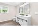 Bathroom with double sinks, shaker-style cabinets, modern mirrors and lighting at 2616 Bullock Rd, Durham, NC 27704