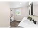 Modern bathroom featuring double sinks, marble-style tile, a walk-in shower, and natural light at 2616 Bullock Rd, Durham, NC 27704