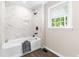 Beautiful bathroom features modern tub with marble-style tile surround and black matte hardware at 2616 Bullock Rd, Durham, NC 27704