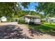 Cozy one-story home with a covered front porch, an adjacent carport, and a gravel driveway at 2616 Bullock Rd, Durham, NC 27704