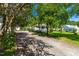 Quaint one-story home with a covered front porch, nestled among mature trees and a gravel driveway at 2616 Bullock Rd, Durham, NC 27704