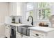 Bright kitchen featuring a farmhouse sink, modern fixtures, white cabinets, and lots of light at 2616 Bullock Rd, Durham, NC 27704