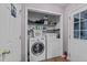 Functional laundry room featuring washer, dryer, and built-in shelving for organized storage solutions at 2825 Alder Ridge Ln, Raleigh, NC 27603