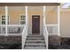 Inviting front porch featuring stone accents, white railing and a covered entryway at 297 Lane Store Rd, Franklinton, NC 27525