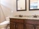 Elegant bathroom featuring dual sinks with granite countertops and dark wood cabinets at 3037 Willow Ranch Dr, Fuquay Varina, NC 27526