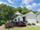 Charming home with gray siding, stone accents, and lush landscaping with blooming flowers at 3037 Willow Ranch Dr, Fuquay Varina, NC 27526