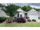 Charming home with gray siding, stone accents, and lush landscaping with blooming flowers at 3037 Willow Ranch Dr, Fuquay Varina, NC 27526