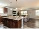 Open concept living area featuring a granite island, sleek fireplace, and hardwood floors at 3037 Willow Ranch Dr, Fuquay Varina, NC 27526