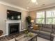 Comfortable living room with a fireplace, mounted television, and a plush gray sectional sofa at 3037 Willow Ranch Dr, Fuquay Varina, NC 27526