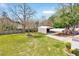 Large, fenced backyard featuring a spacious lawn, metal storage building and covered parking area at 309 W Parrish Dr, Benson, NC 27504