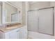 Well-lit bathroom with a vanity, sink, and a shower tub with sliding glass doors at 309 W Parrish Dr, Benson, NC 27504