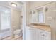 Bathroom featuring a toilet, vanity with sink, and a large mirror at 309 W Parrish Dr, Benson, NC 27504