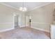 Spacious dining room showcasing neutral paint, trim detail, chandelier, and open doorway at 309 W Parrish Dr, Benson, NC 27504
