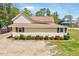 Single-story home featuring vinyl siding, a well-kept lawn, and manicured bushes at 309 W Parrish Dr, Benson, NC 27504