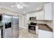 Bright kitchen with stainless steel appliances, granite counters and white cabinetry at 309 W Parrish Dr, Benson, NC 27504
