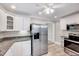 Bright kitchen with stainless steel appliances, granite counters and white cabinetry at 309 W Parrish Dr, Benson, NC 27504