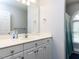 Bright bathroom featuring a white vanity, large mirror, and shower with a window at 3100 Anderson Dr, Raleigh, NC 27609