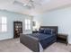 Airy bedroom featuring tray ceilings, comfortable furnishings, and natural light through shuttered windows at 3100 Anderson Dr, Raleigh, NC 27609