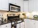 Close-up of a kitchen featuring stainless steel appliances and white cabinets with granite countertops at 3100 Anderson Dr, Raleigh, NC 27609