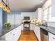 Bright kitchen showcasing stainless steel appliances, white cabinets, granite countertops, and hardwood flooring at 3100 Anderson Dr, Raleigh, NC 27609