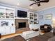 Cozy living room featuring a brick fireplace, built-in bookcases, and large windows at 3100 Anderson Dr, Raleigh, NC 27609
