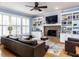 Cozy living room featuring a brick fireplace, built-in bookcases, and large windows at 3100 Anderson Dr, Raleigh, NC 27609