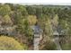 Aerial view of a home nestled in a lush, green neighborhood with mature trees, a private yard, and winding driveway at 311 Lilliput Ln, Wake Forest, NC 27587