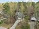 Aerial view of a two-story home featuring lush greenery and a curved driveway leading up to the garage at 311 Lilliput Ln, Wake Forest, NC 27587