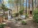 Wooded back yard featuring a covered greenhouse, pond, and playground at 311 Lilliput Ln, Wake Forest, NC 27587