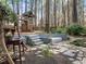 Beautiful wooded backyard featuring a custom-built treehouse, stage, and decorative rock and stone elements at 311 Lilliput Ln, Wake Forest, NC 27587