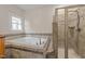 Bathroom featuring tiled shower, separate soaking tub with tiled surround, and ample natural light at 311 Lilliput Ln, Wake Forest, NC 27587